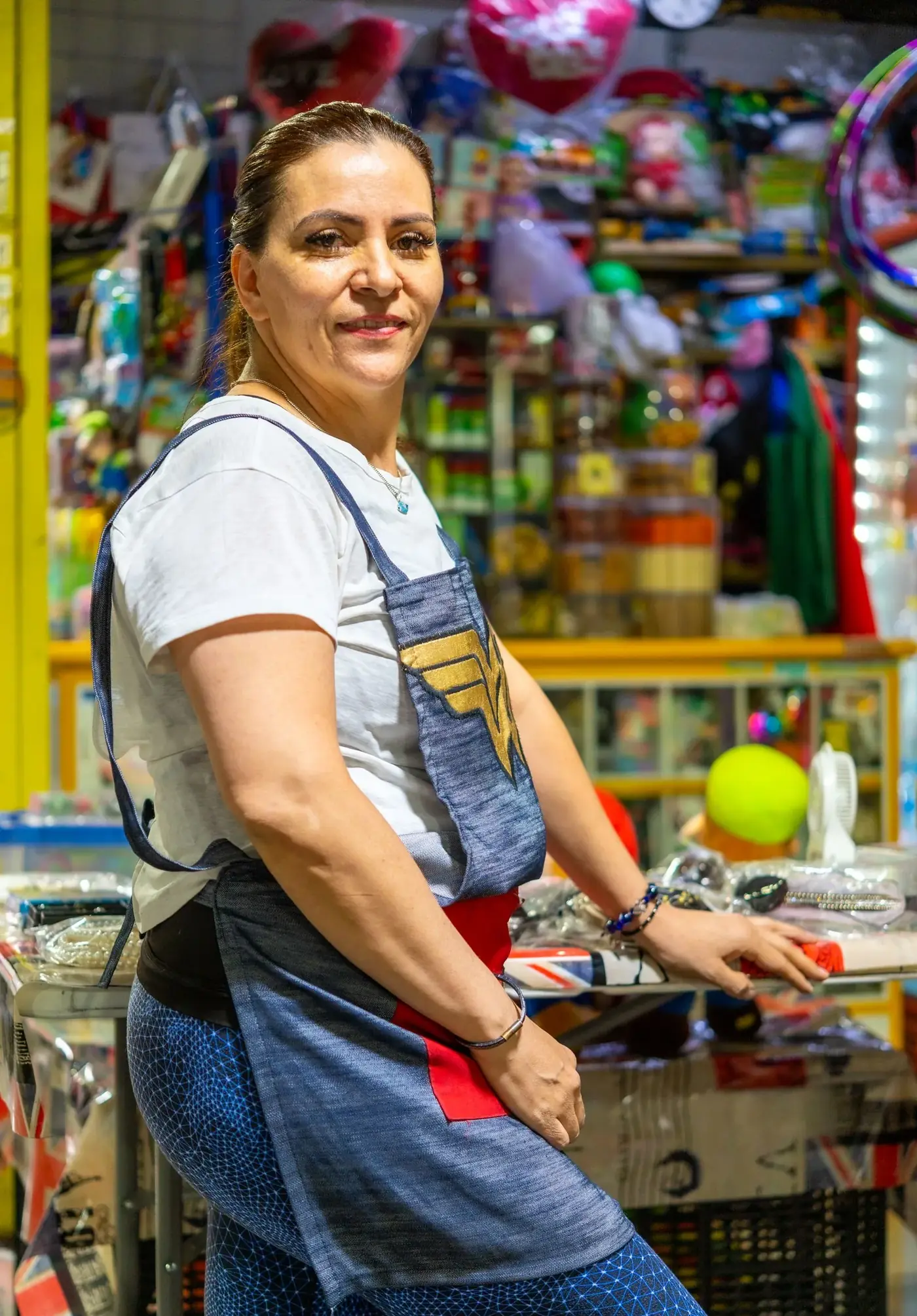 Tendera colombiana atendiendo su tienda de barrio
